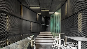 A modern interior with a staircase, white chairs, and a green accent wall. - Blend City Center (Bucharest)
