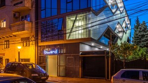 A modern building with a glass facade and a unique angular design. - Blend City Center (Bucharest)