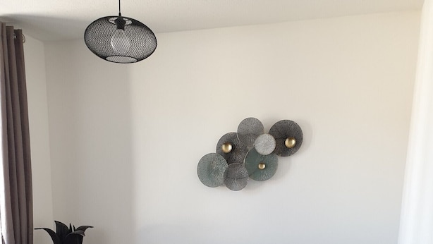 Una sala de estar moderna con un sofá gris, una mesa de centro negra y una alfombra gris.