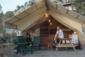 A tented accommodation with a dining area, green chairs, and a table. - Glamping Tent near Zion with 2 Queen Beds & A/C (Orderville)