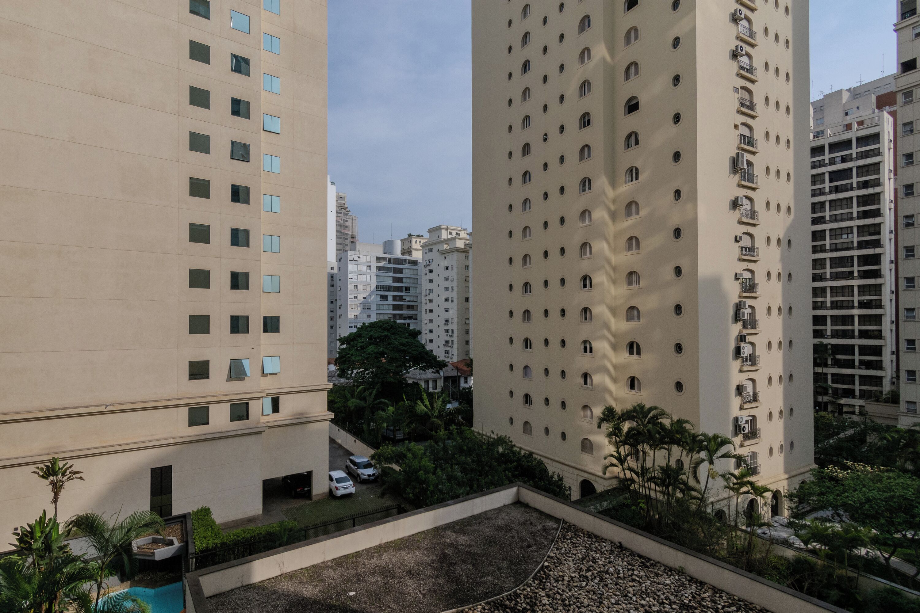 A high-rise building with multiple balconies and a rooftop pool area.