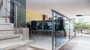 Un espacio interior moderno con una escalera que lleva a una zona de estar con sillas.