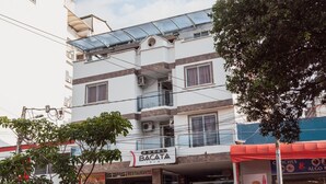 A multi-story hotel with a restaurant on the ground floor, a visible staircase, and a parked police vehicle. - Hotel Bacata Isla (Bucaramanga)