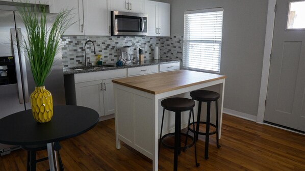 Enjoy cooking in this kitchen with a central island, bar stools, microwave, and cabinets.