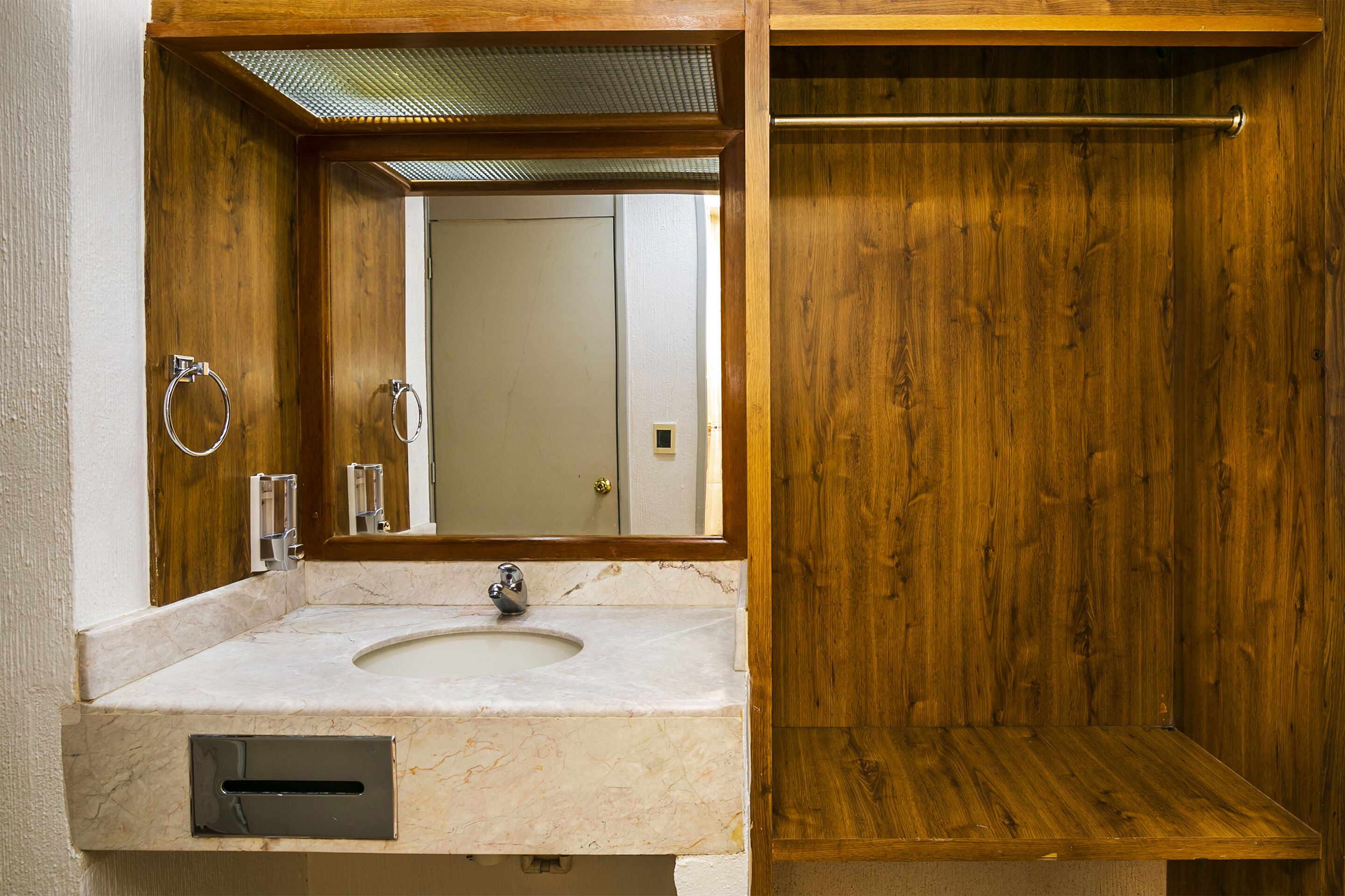 A bathroom with a wooden vanity, a sink, and a mirror.
