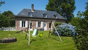 A brick house with a sloped roof, a swing set, and a green slide in the yard. - THE PIRATES FARM (MANNEVILLE la raoult)