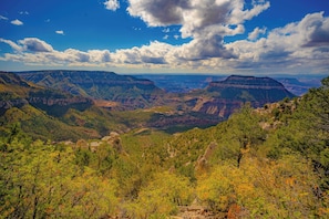 A mountainous landscape with a valley, trees, and a clear sky.