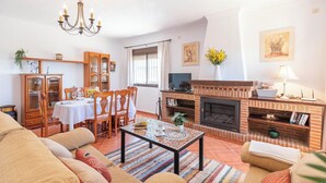 A cozy living room with a fireplace, dining area, and comfortable seating. - Villa Gema Antequera - La Joya by Ruralidays (Málaga)