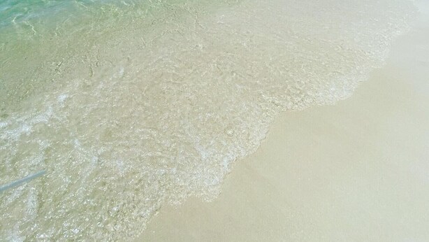 Uma praia com águas turquesa cristalinas e uma faixa de areia.