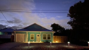 Uma casa térrea com fachada azul e uma garagem.