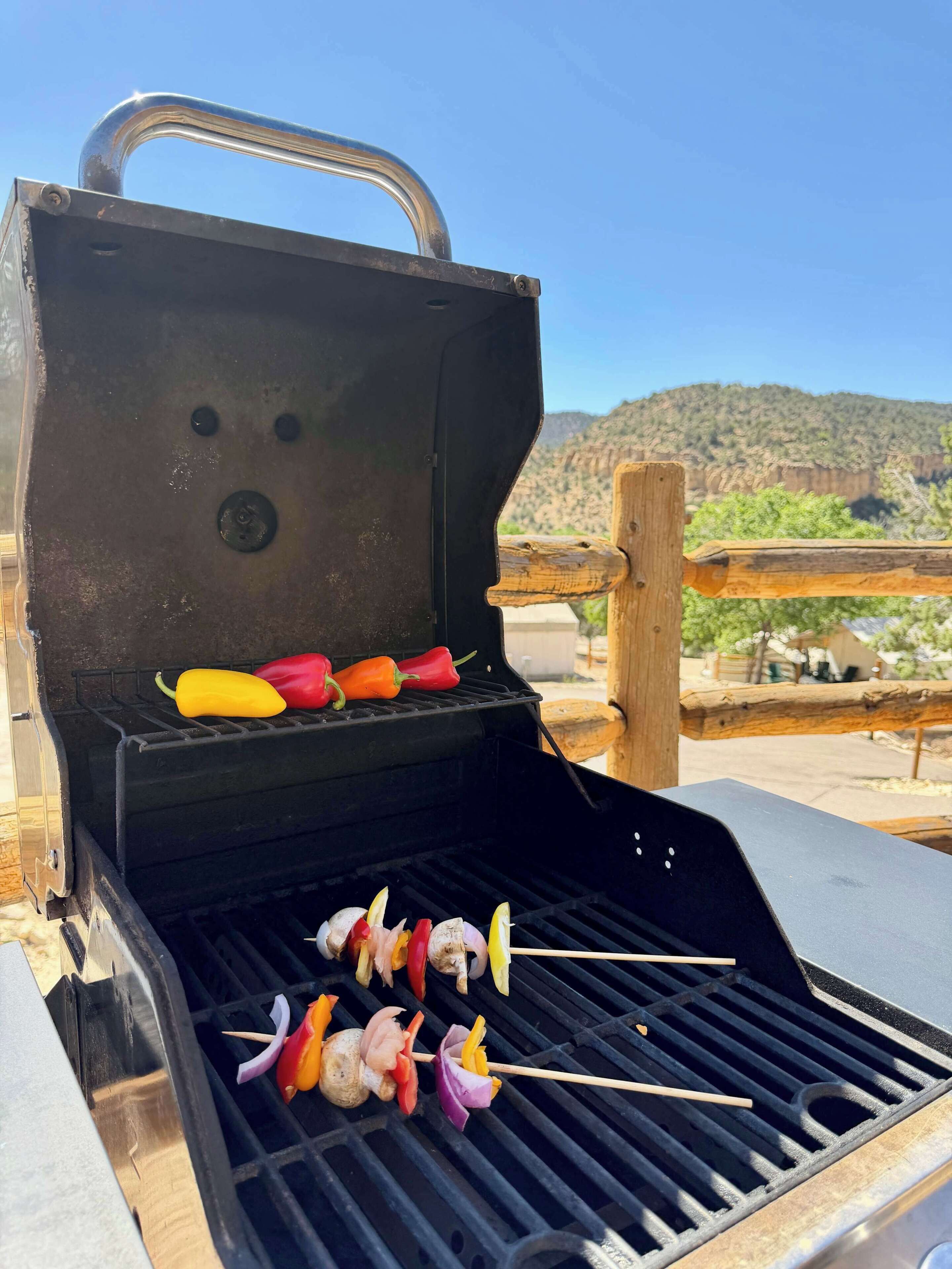 Una parrilla con brochetas de verduras y pimientos.