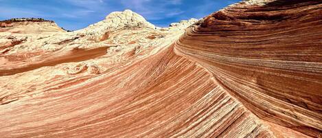 A canyon with layered rock formations and a clear sky.