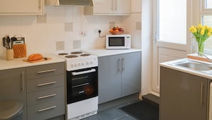 Una cocina moderna con estufa, horno, microondas y ventana con vistas.