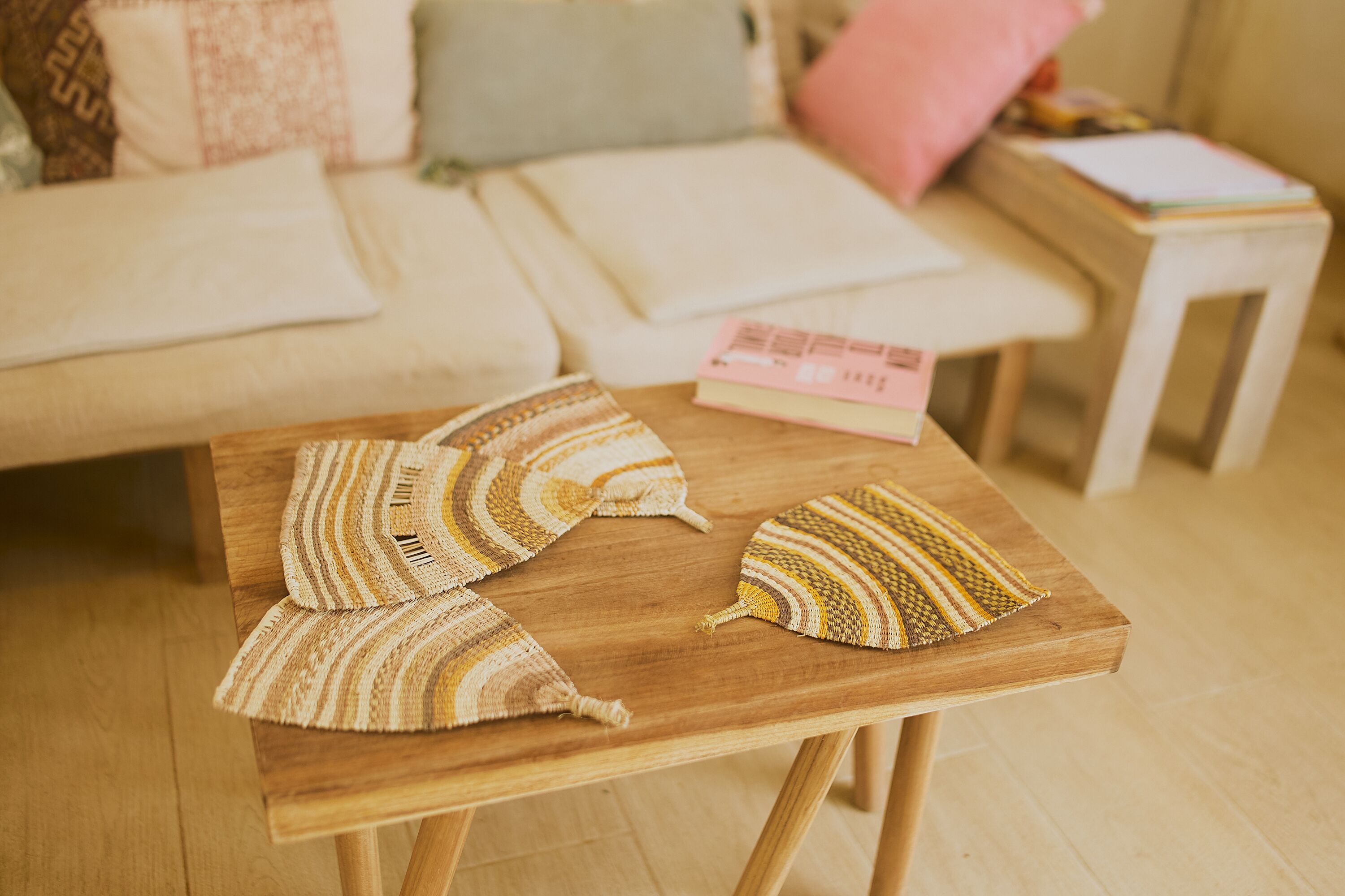 Una mesa de madera con cojines a rayas y un libro encima.