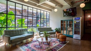 A modern living room with a sofa, armchairs, a coffee table, and a patterned rug. - Viajero Hostel Medellin (Medellín)