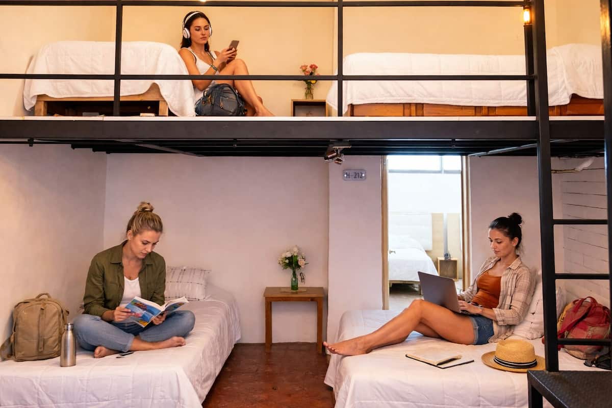 Un dormitorio con literas, una mesita con un florero y una puerta con la etiqueta 'H-212'.