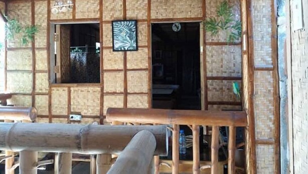 A traditional Japanese-style building with tatami mat flooring, wooden beams, and a bamboo fence. - Ferrer's Villa Apt 2 close to beaches, parks, banks, market and parks. (Romblon Odiongan)