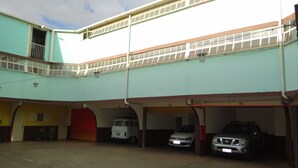 A multi-level parking structure with several cars parked under covered areas. - Hotel Bonança (Samambaia)