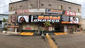 A hotel with a prominent 'HOTEL Orange' sign, a 24-hour service indication, and a contact number. - Hotel Bonança (Samambaia)