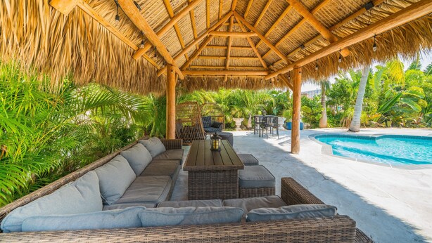 A covered outdoor seating area with a pool. - Luxury Water Front Villa! (Pompano Beach)