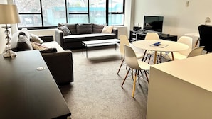 Una sala de estar moderna con sofá, mesa de centro y comedor.