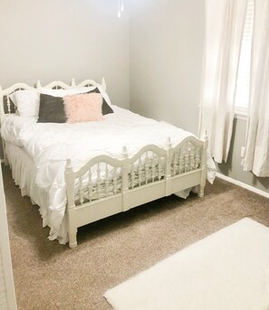 A white bed with a wooden headboard in a room with beige carpet. - Masters Rental 2020! (Augusta)