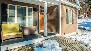 A house with a porch, a number 45 sign, and a green sofa. - Beautiful New Home!! (Intervale)