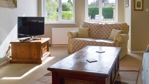 A living room with a television, sofa, and coffee table. - 3 bedroom accommodation in Sheringham (Sheringham)