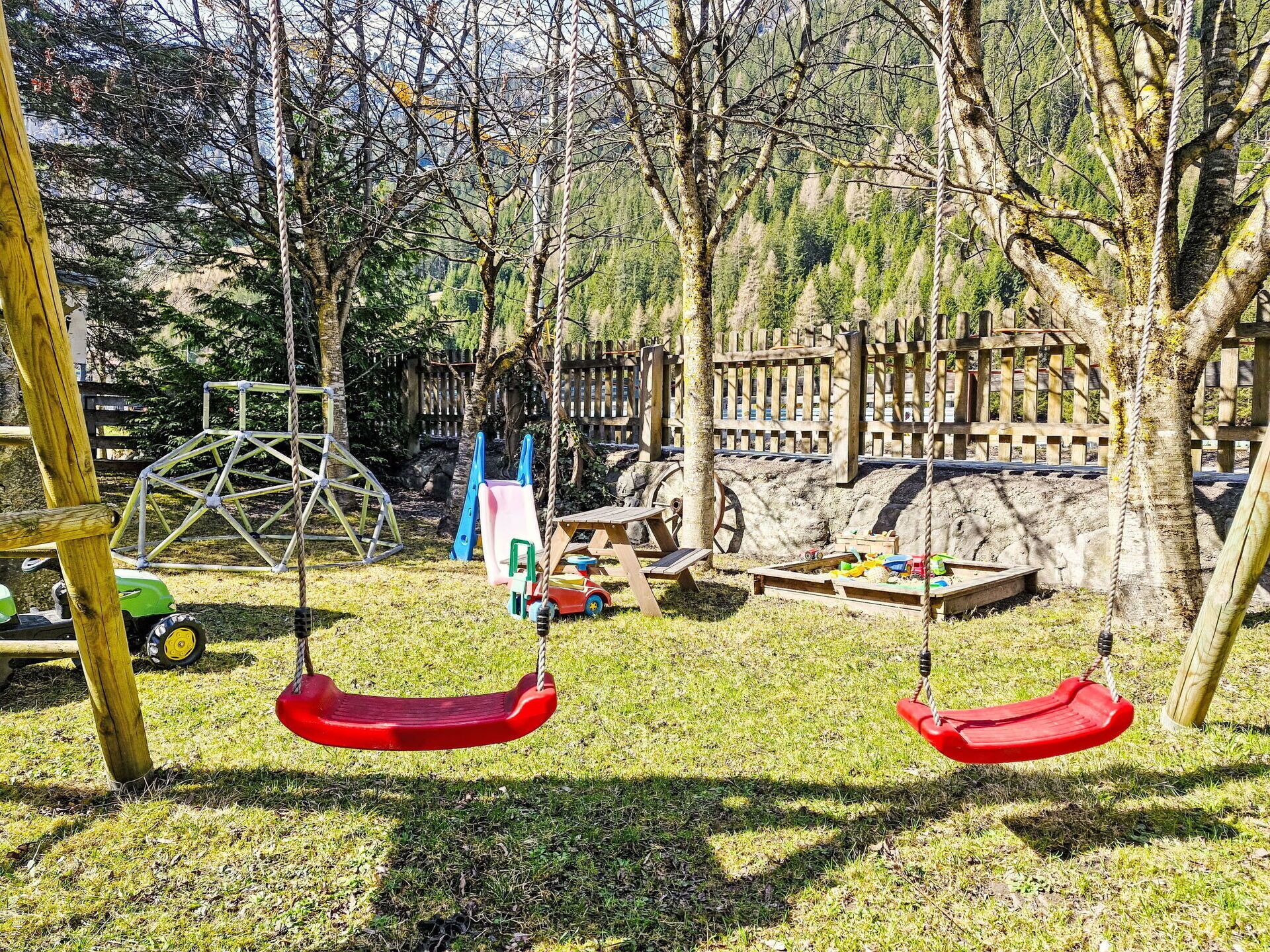 A playground with swings, a slide, and a climbing structure.