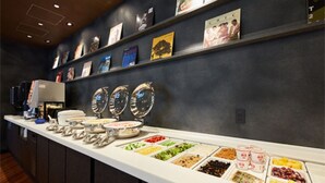 A buffet with various food options and a wall with framed pictures. - Rembrandt Style Honatsugi (Atsugi)