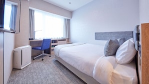 A hotel room with a bed, a desk with a chair, a flat-screen TV, and a window with curtains. - Rembrandt Style Honatsugi (Atsugi)