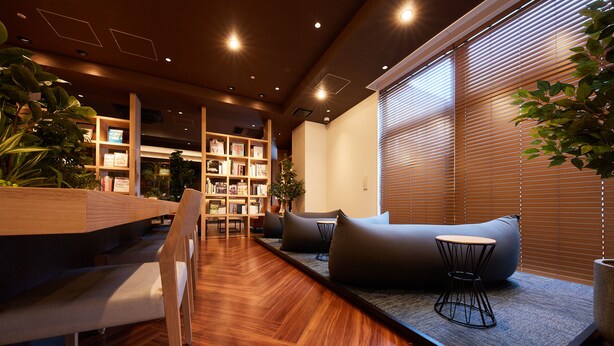 A modern interior with a wooden floor, a sofa, a small table, and a bookshelf. - Rembrandt Style Honatsugi (Atsugi)