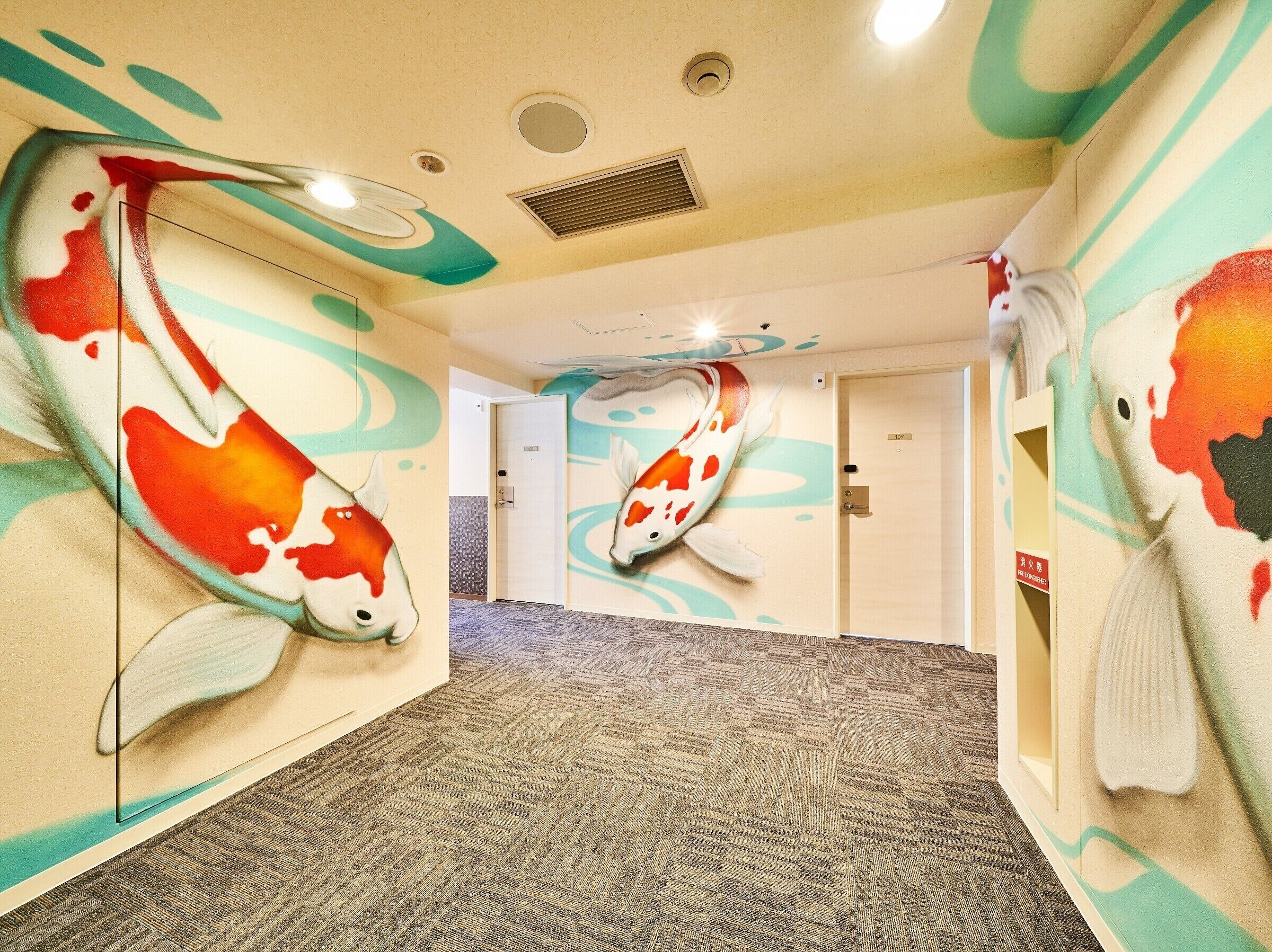 Pasillo de hotel con paredes decoradas con murales de peces koi, suelo alfombrado y una puerta con un letrero.