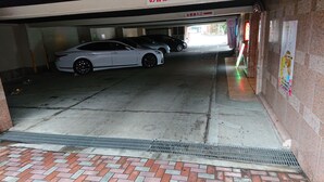 A parking garage with two cars parked under a building. - Hotel Zips - Adults Only (Kawaguchi)