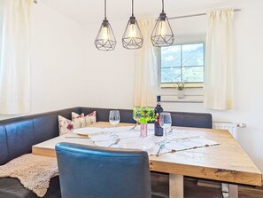 A dining area with a wooden table, black leather seating, and pendant lights. - Lovely apartment for 3 people with WIFI, TV and balcony (Untermärz)