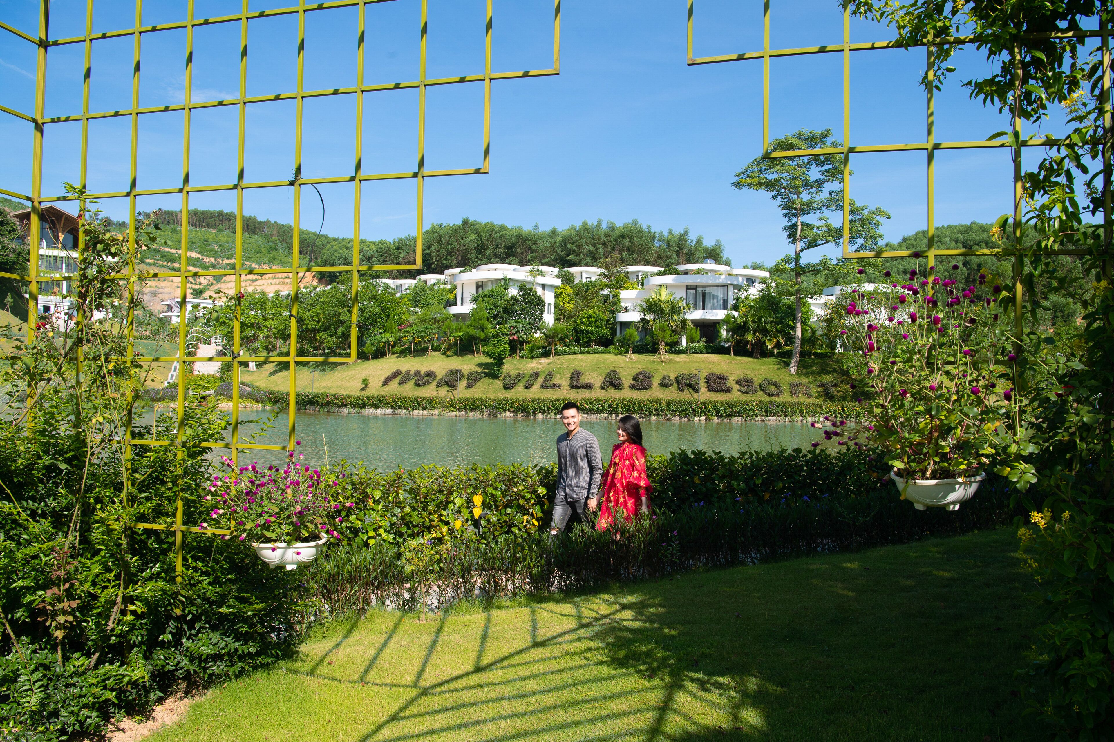 Una vista del Map Villas Resort con un lago, vegetazione e cielo sereno.
