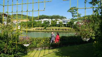 Una vista del Map Villas Resort con un lago, vegetazione e cielo sereno.