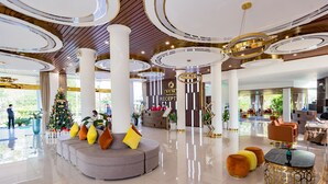 Un moderno vestíbulo de hotel con mostrador de recepción, zona de estar y ventanas amplias.