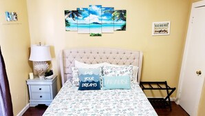 A bedroom with a bed, a nightstand, a lamp, and a wall art piece. - Canal-Front Home, 2-Min Drive to Beach, Fishing Pier. (Galveston)