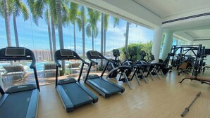 A gym with treadmills, weight machines, and a bench. - Casa Frida: Luxe Pier 57 Oceanview Corner Unit (Puerto Vallarta)