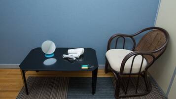 A small room with a black table, a chair, and a blue wall.