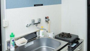 A compact kitchen with a sink, stove, and cabinets. - Uzumasa 201 (Kyoto)