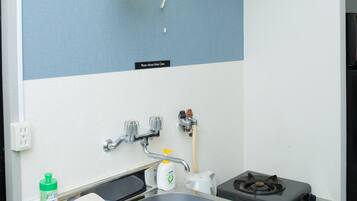 A compact kitchen with a sink, stove, and cabinets.