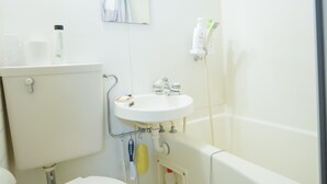 A small, white bathroom with a toilet, sink, and bathtub. There is a mirror above the sink and a towel hanging on the wall. - Uzumasa 201 (Kyoto)