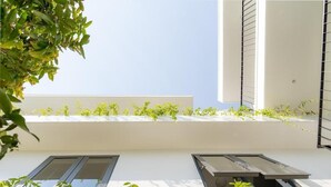 Un bâtiment moderne doté d’un toit plat, de murs blancs et d’une série de fenêtres.