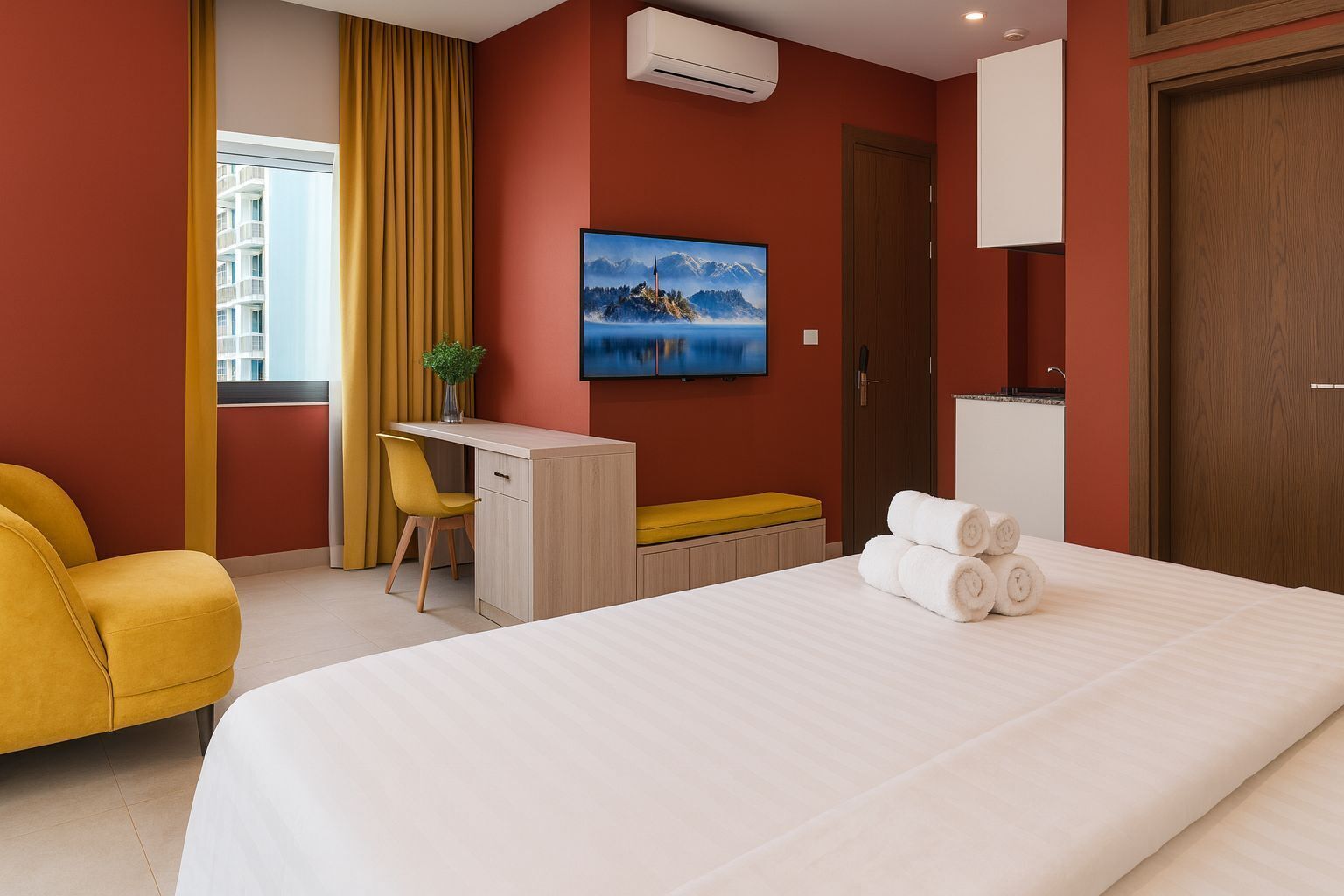 A hotel room with a bed, a desk, a chair, a TV, and a door.