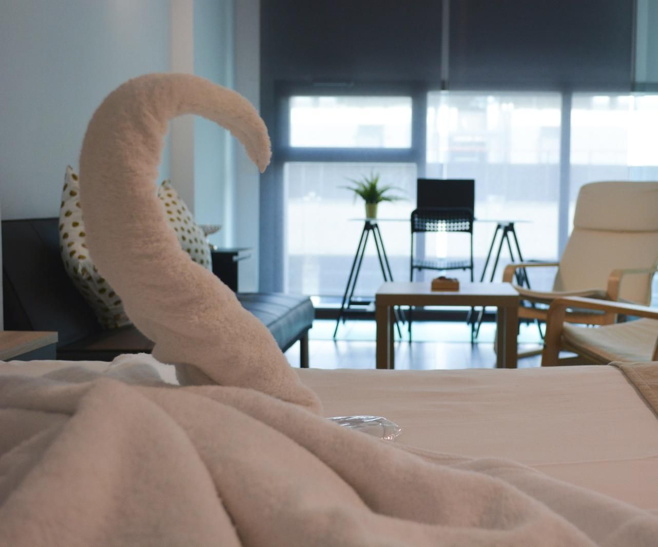 Una habitación de hotel moderna con una cama grande, un escritorio y dos sillas.