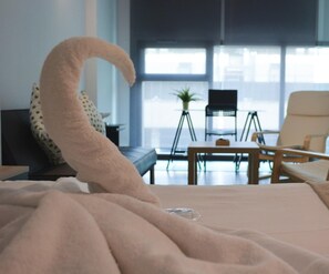Quarto de hotel moderno com uma cama grande, uma mesa e duas cadeiras.