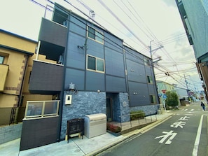 Two-story building with a flat facade and a mix of horizontal and vertical lines.