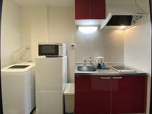 Une petite cuisine équipée d’un four à micro-ondes, d’un petit réfrigérateur, d’un évier et d’une machine à café.